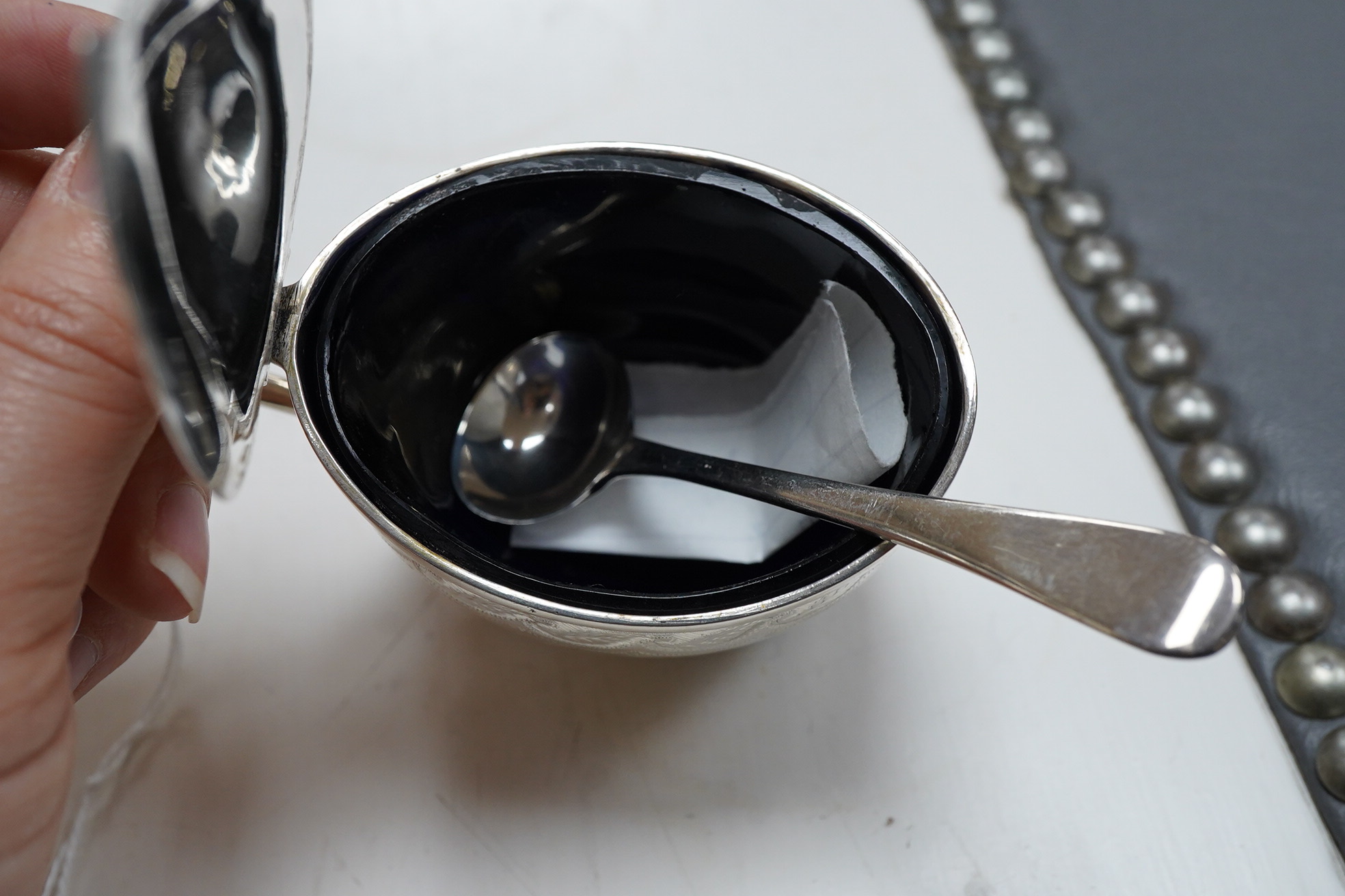 A George III engraved oval silver mustard pot, by James Mince, London, 1805, height 69mm, together with an associated silver mustard ladle, Thomas Dicks, London, 1808.